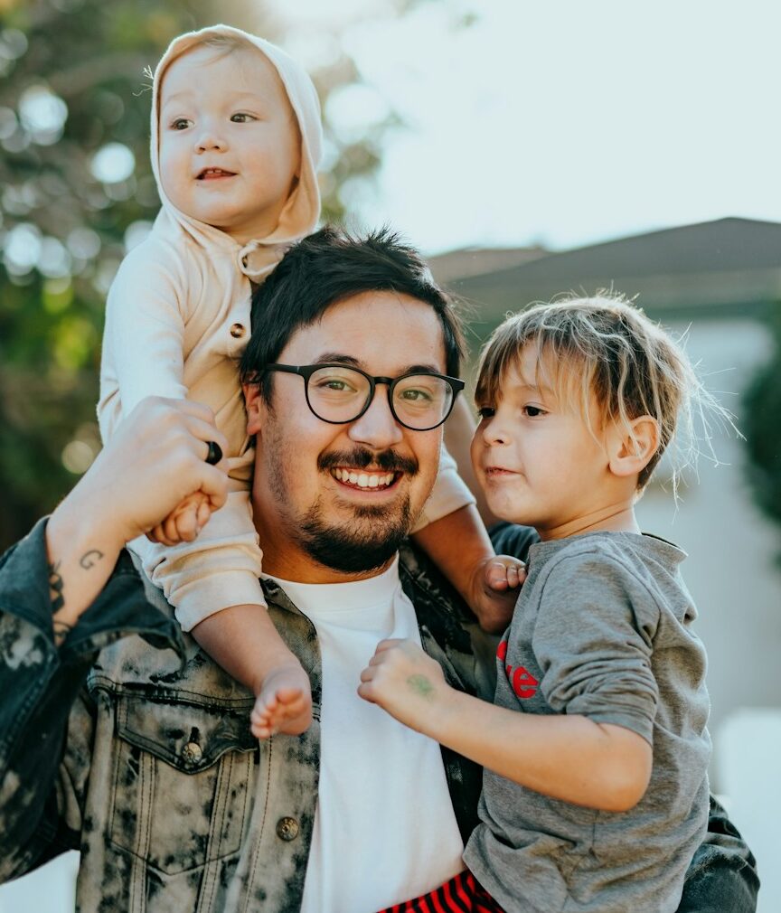 man in white shirt carrying girl in gray shirt